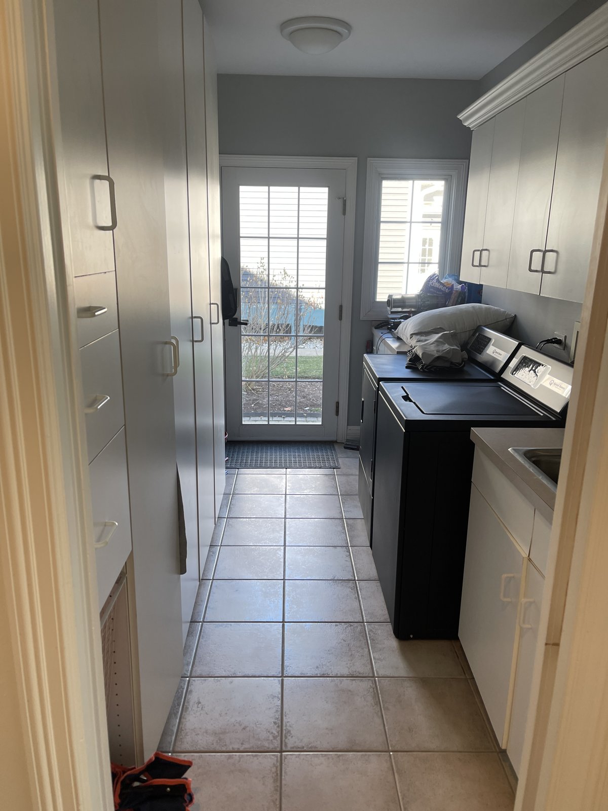 Before: plain white mudroom galley with builder-grade cabinets