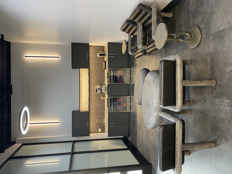 Commercial lounge with dark cabinetry, beverage bar and sculptural stone seating