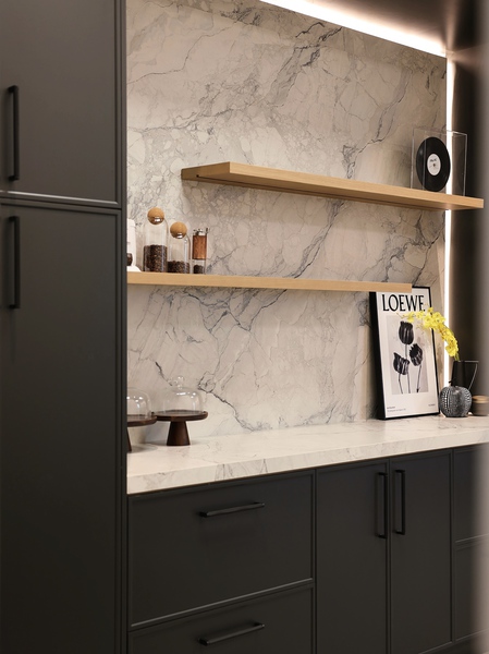 Butler's pantry with dark cabinetry and marble backsplash