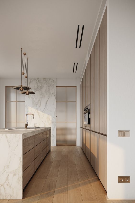 Warm minimal kitchen with marble island and wood cabinetry