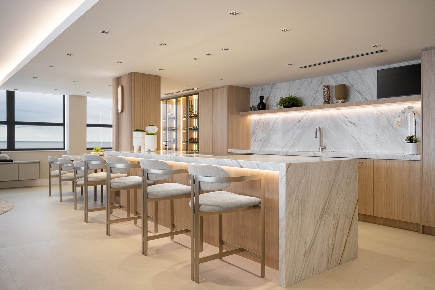 White oak modern condo kitchen with marble waterfall island and lake view