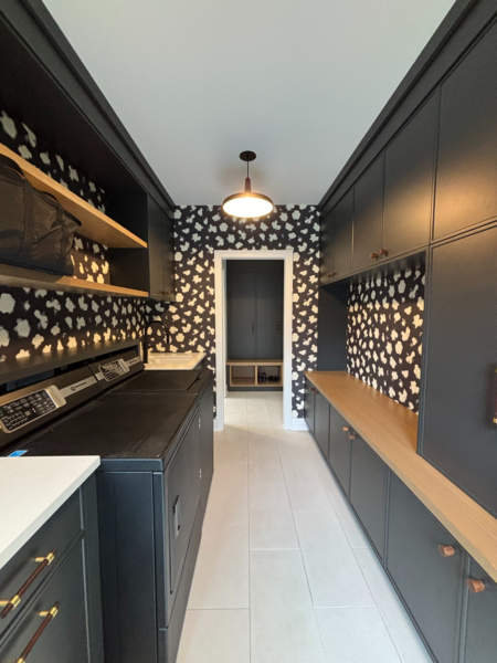 Modern galley mudroom with black cabinetry and patterned wallpaper